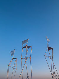 Low angle view of windmill against clear blue sky