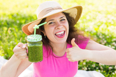 Portrait of a smiling young woman holding hat