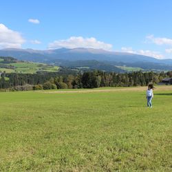 Full length of woman on green hill