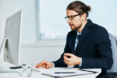 Young man using mobile phone while sitting on table