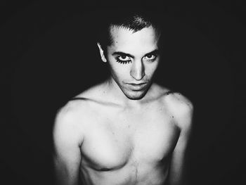 Portrait of young man against black background