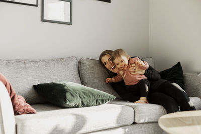 Mother with toddler girl on sofa