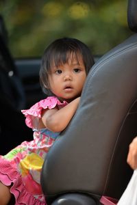 Portrait of cute girl sitting in car