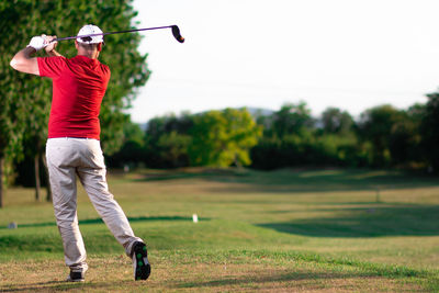 Full length of man playing on golf course