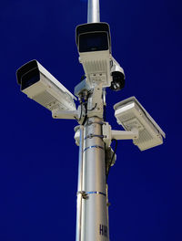 Low angle view of telephone pole against blue sky