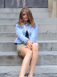 Young woman sitting on staircase