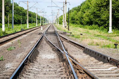 Railroad tracks by trees against sky