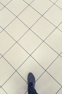 Low section of man standing on tiled floor