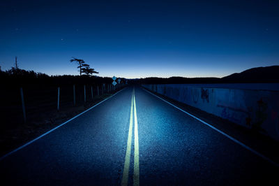 Empty road against sky at night