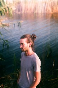 Young man standing at lake