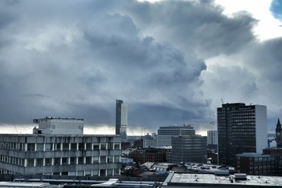 Buildings in city against cloudy sky