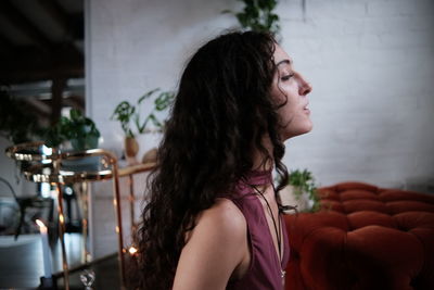 Young woman looking away while sitting at in a beautiful location indoors, spiritual 