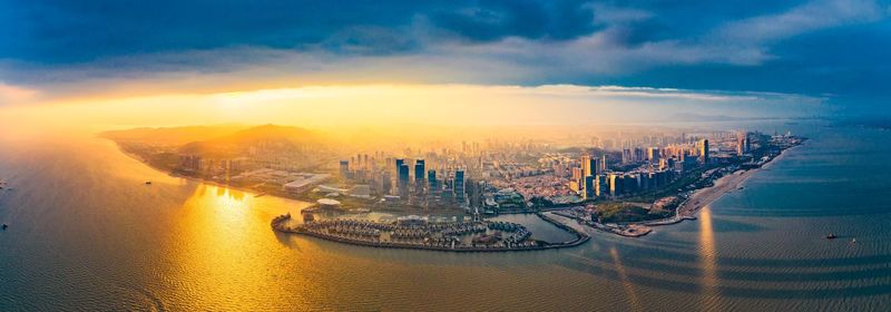 Aerial view of buildings in city during sunset