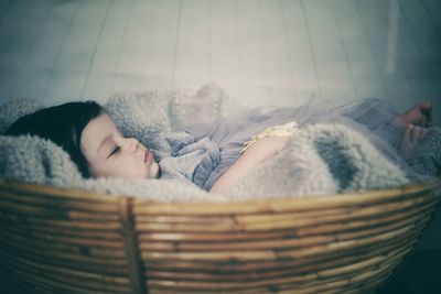 Cute baby girl sleeping in basket