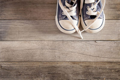 Low section of shoes on hardwood floor