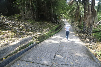 Rear view of teenage girl jogging on footpath