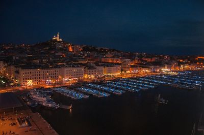 High angle view of illuminated town against sky at night