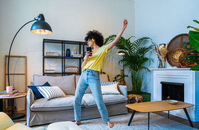 Rear view of woman sitting on bed at home