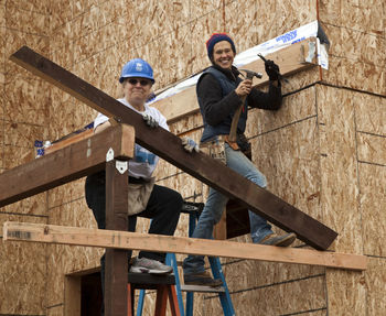 Man working with arms outstretched standing on wood