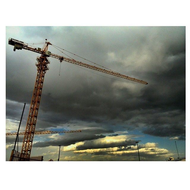 transfer print, auto post production filter, sky, low angle view, fuel and power generation, technology, electricity, power supply, cloud - sky, crane - construction machinery, electricity pylon, cloudy, power line, weather, environmental conservation, construction site, connection, development, industry, crane