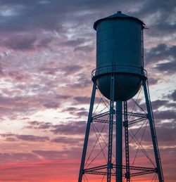 Low angle view of water tower against sky during sunset