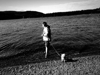 Woman with dog standing in water