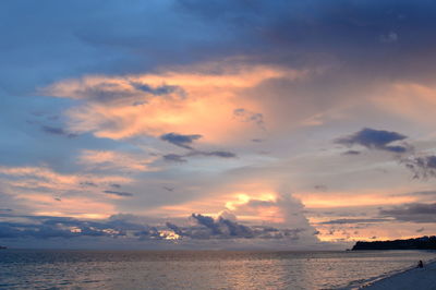 Scenic view of sea against dramatic sky during sunset