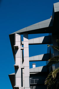 Low angle view of modern building against clear blue sky