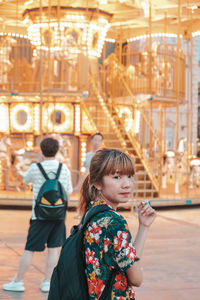 Portrait of girl standing against building in city