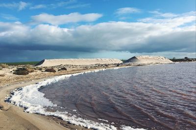 View of beach against cloudy sky