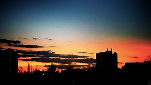 Low angle view of silhouette built structures at sunset