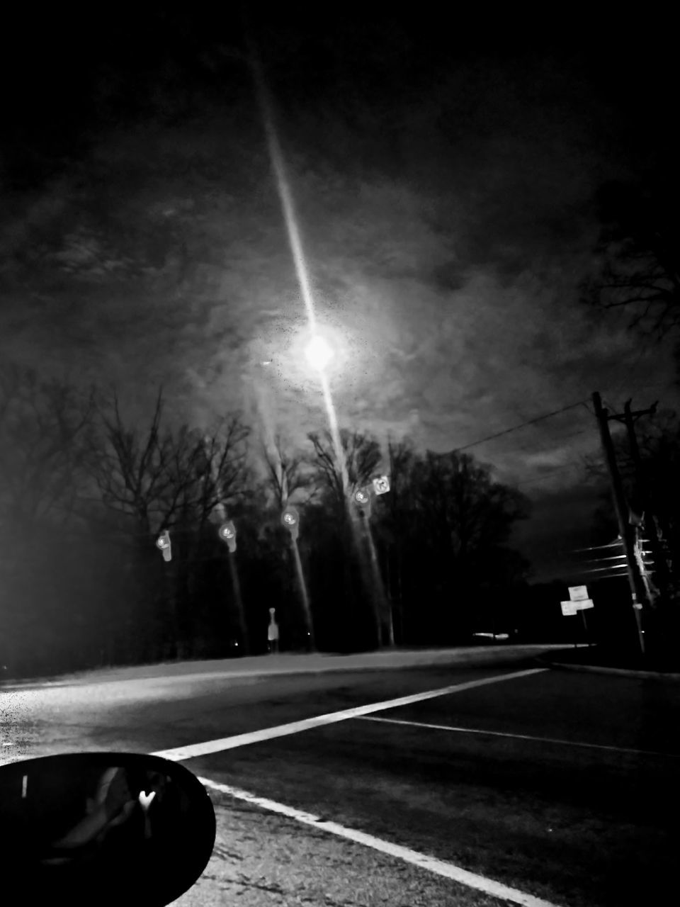 darkness, light, transportation, road, night, black and white, tree, black, car, monochrome, motor vehicle, mode of transportation, sky, nature, monochrome photography, sign, street, road marking, marking, plant, white, no people, land vehicle, outdoors, symbol, city, cloud