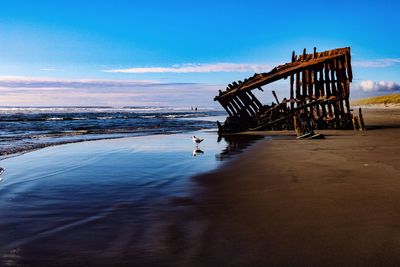 Lifeguard hut on beach against sky