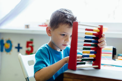 Close-up of boy using abacus