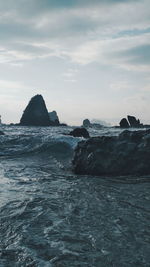 Scenic view of rock formations in sea against sky