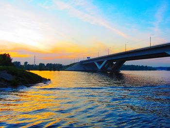 Bridge over river against sky during sunset