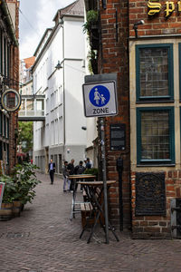 Road sign on street amidst buildings in city