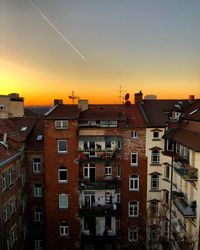 Residential buildings against sky during sunset