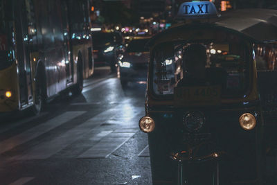 Jinrikisha on road in city at night