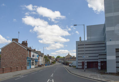 Road amidst buildings against sky