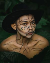 Close-up portrait of young woman wearing hat