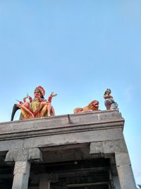 Low angle view of bird statue against clear blue sky