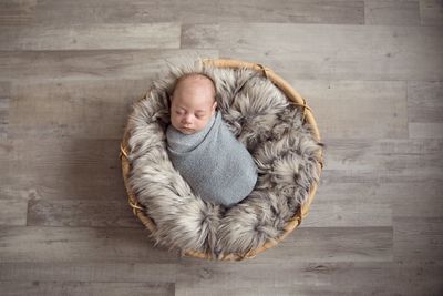 High angle view of cute baby boy sleeping in basket