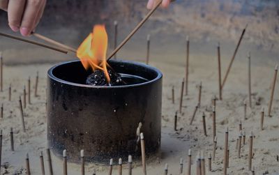 Cropped hands of people burning incense