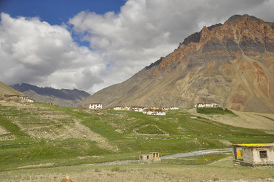 View of a village next to a beautiful rocky mountain with flowing a river 