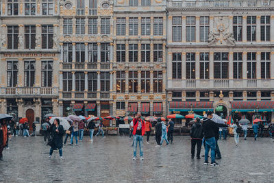 People walking on street against buildings in city