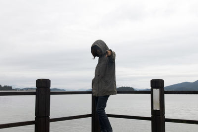 Rear view of woman looking at sea against sky