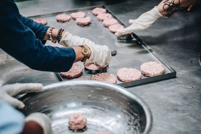 Cropped hands of women preparing food in kitchen