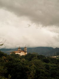 Building on mountain against cloudy sky