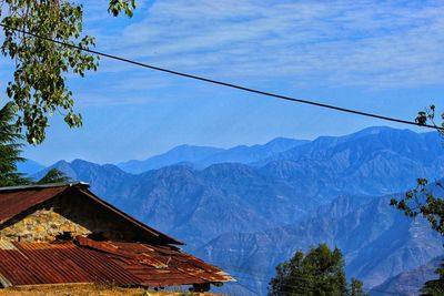 Houses by mountains against sky